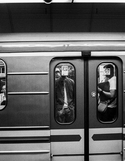 Blick auf wartende Passagiere durch die geschlossenen Türen einer U-Bahn.