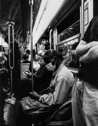 Menschen mit Masken in einer Pariser U-Bahn, Schwarz-Weiß-Foto.