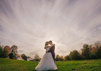 Hochzeitspaar im Gegenlicht bei Sonnenuntergang, festgehalten von Fotograf Dennis Weissmantel.
