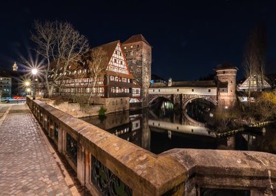Fachwerkhäuser, Brücke und Fluss im nächtlichen Nürnberg, fotografiert mit Langzeitbelichtung.