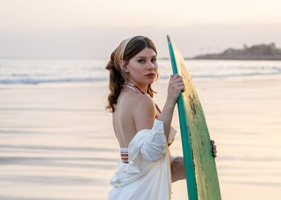Frau mit Surfbrett am Strand bei Sonnenuntergang, fotografiert von Thomas Adorff.