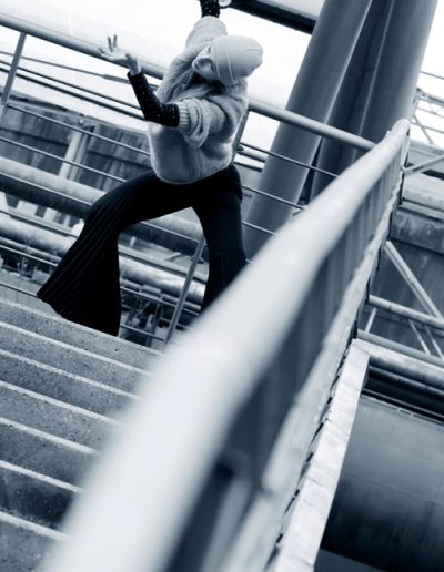 Tänzerin posiert auf einer Treppe in Industrieumgebung, fotografiert von Paul Leclaire.