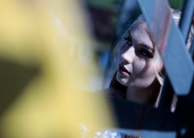 Frau hinter dunklen Gitterstrukturen, Unschärfe im Vordergrund.