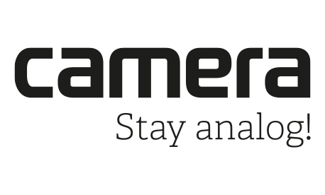 Logo von camera: Schwarzer Schriftzug „camera“ in moderner Typo mit Claim „Stay analog!“ darunter auf weißem Hintergrund