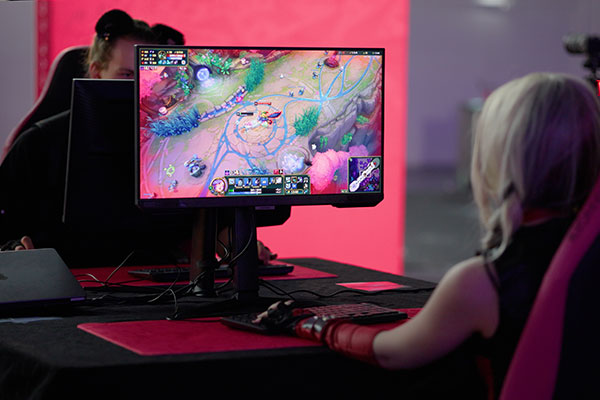 Teilnehmer spielen ein eSport-Match am Gaming-Setup im Playground-Bereich der Imaging World 2025.