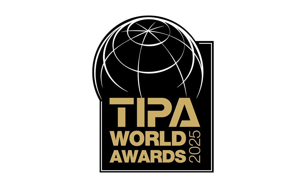 Official logo of the TIPA World Awards 2025 Logo of the TIPA World Awards 2025: Golden lettering “TIPA WORLD AWARDS 2025” on a black background with a stylized globe above - a symbol of international excellence in the photography industry.