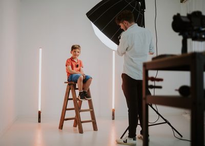 Fotograf stellt Licht für Kinderportrait im Studio ein