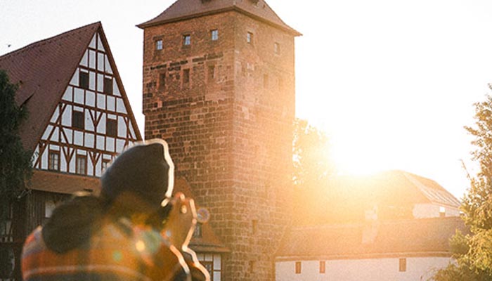 Fotograf beim Sunrise-Fotowalk in der Nürnberger Altstadt – historische Fachwerkhäuser im Morgenlicht. Workshop mit Kristof Göttling für Stadtfotografie bei Sonnenaufgang.