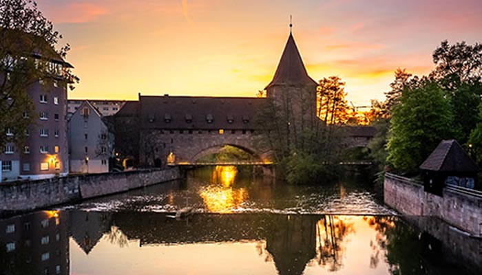 Abendstimmung bei Sunset-Fotowalk in der Nürnberger Altstadt – Spiegelung der Stadt im Fluss zur Blauen Stunde. Fotoworkshop mit Kristof Göttling für Stadtfotografie im Abendlicht.