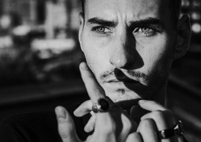 Nahaufnahme eines Mannes mit Ringen, dramatisches Licht- und Schattenspiel im Gesicht.